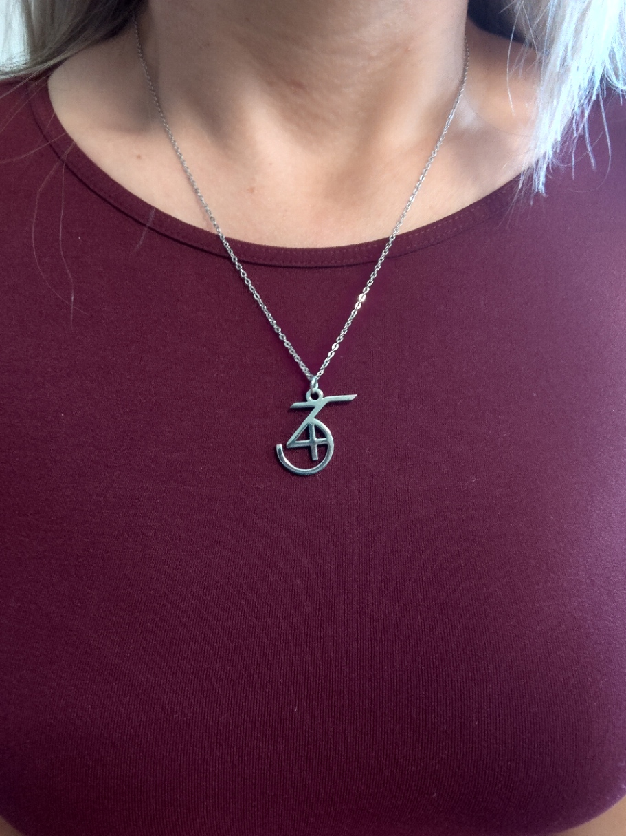 Silver necklace with a 345 pendant worn by a woman in maroon shirt